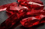 Rubies and raw crystal gems concept with closeup of a bunch of red rough uncut ruby crystals